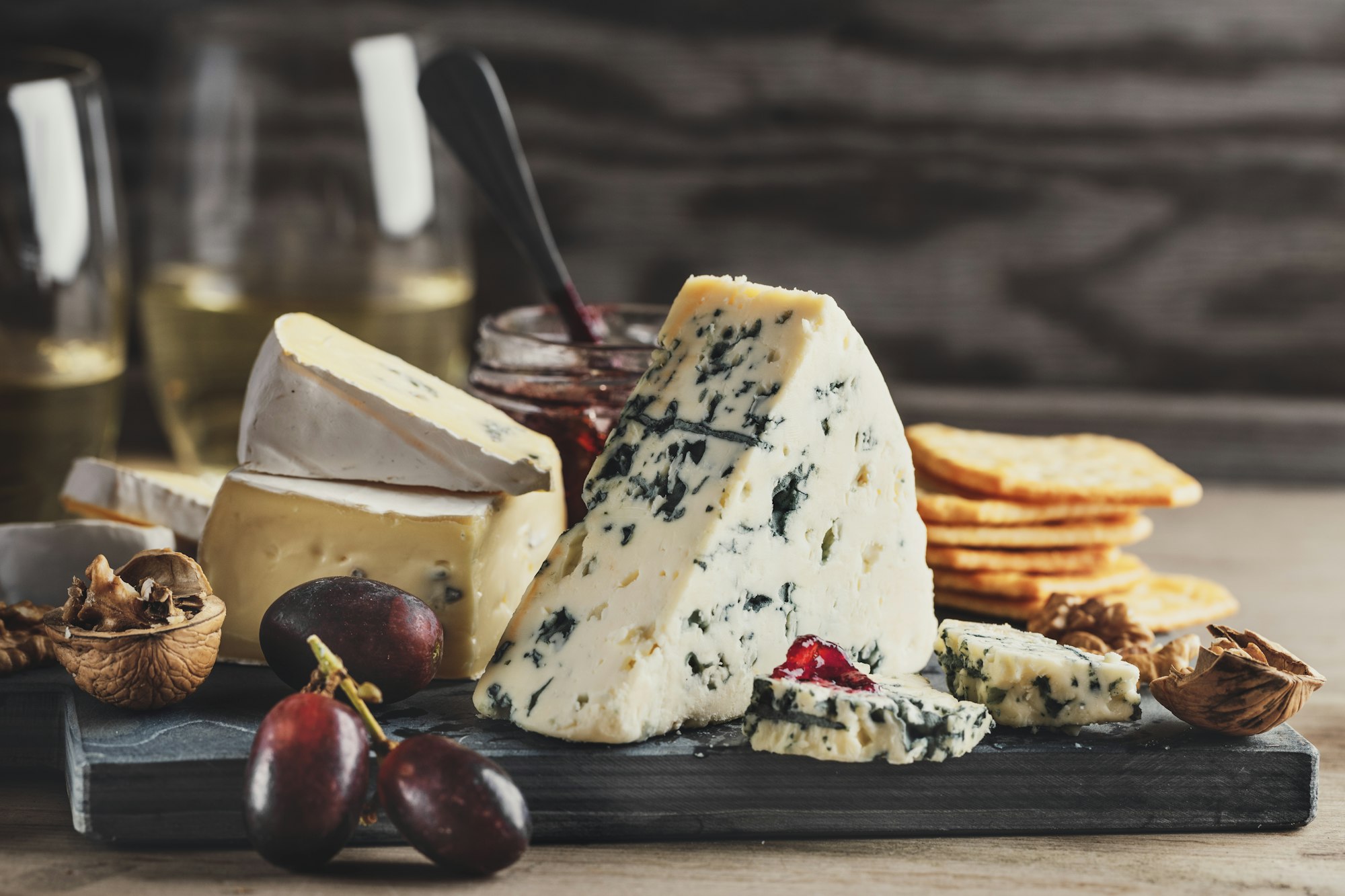 Different arts of cheese with grape on wooden